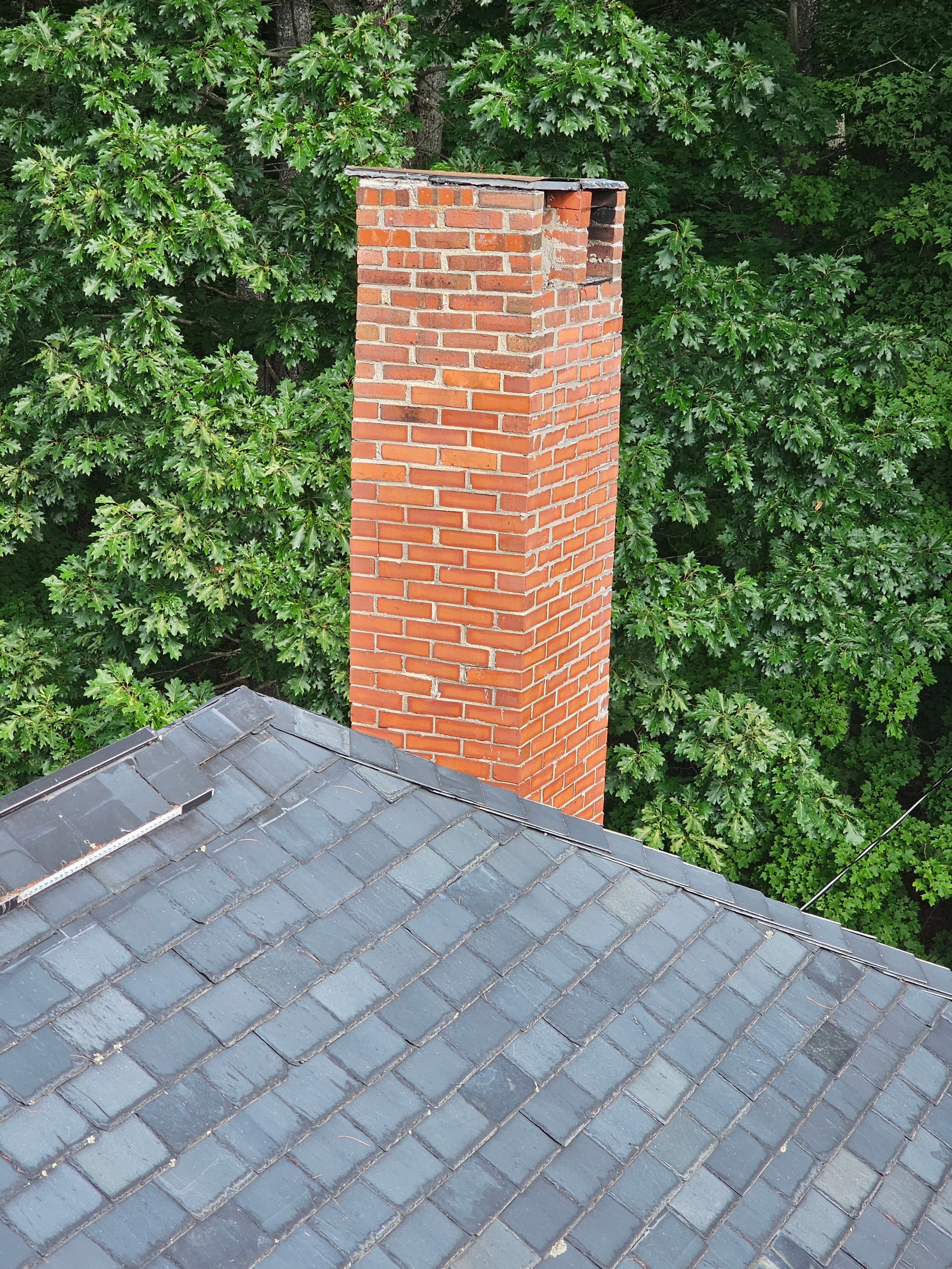 Chimney before restoration — damaged upper section